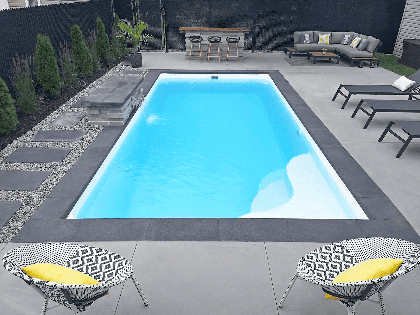 Completed fiberglass pool with lounge chairs