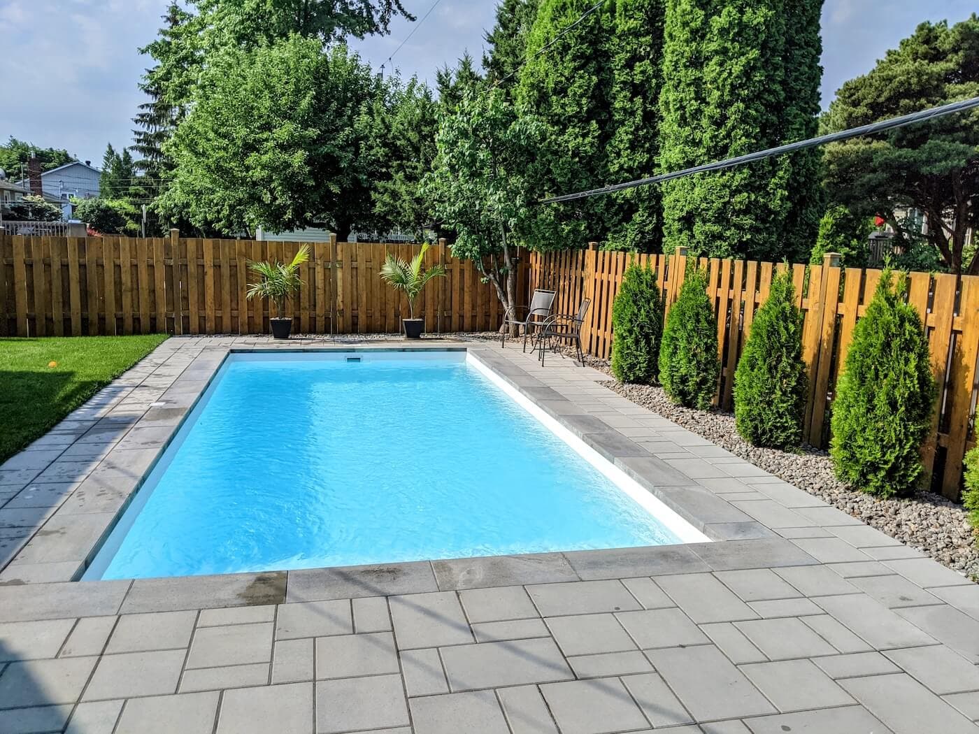 Fiberglass pool surrounded by evergreen trees